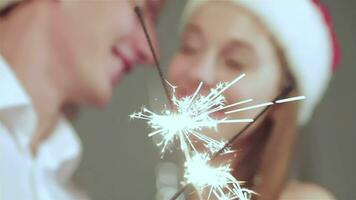 bellissimo coppia nel Santa cappello Tenere sparklers nel mano e bacio video