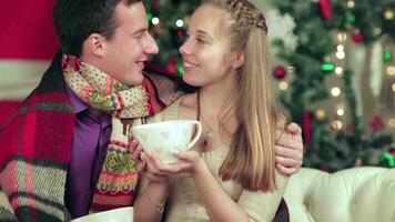 Young couple in love man and pretty girl wearing sweater and scarf at home video