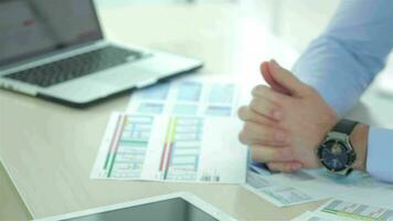 A desk covered in papers and the hands of a businessperson video