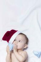 9 month baby boy with Santa Claus hat. Christmas morning. Little kid playing. photo