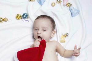 9 month baby boy with Santa Claus hat. Christmas morning. Little kid playing. photo