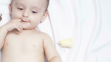 Baby boy playing with christmas balls and toys photo