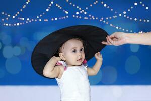 1 año bebé niña en bruja sombrero. Víspera de Todos los Santos celebracion concepto foto