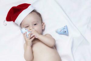 9 month baby boy with Santa Claus hat. Christmas morning. Little kid playing. photo