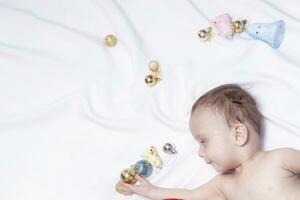 Baby boy playing with christmas balls and toys photo