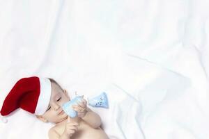 9 month baby boy with Santa Claus hat. Christmas morning. Little kid playing. photo