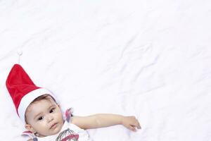 Little Santa. 1-year-old baby girl in Santa Claus hat. Merry Christmas. Adorable middle-eastern girl in Santa cap. photo