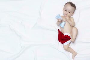 9 month baby boy with Santa Claus hat. Christmas morning. Little kid playing. photo
