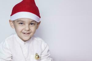 Happy little christmas boy. Celebrating Christmas. 6-7 year old kid with Santa hat. photo