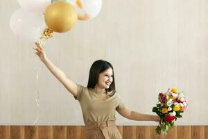 retrato de encantador, bonito niña participación ramo de flores de flores y caliente aire globos foto