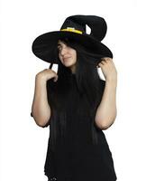 Portrait of young woman in witch costume isolated on white background. Halloween theme on white photo