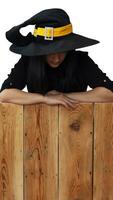Víspera de Todos los Santos niña en bruja disfraz en de madera tablero foto