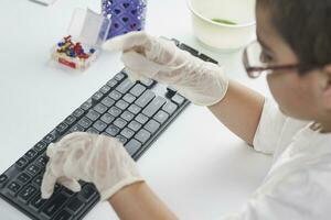 Overhead view of schoolboy typing on keyboard photo