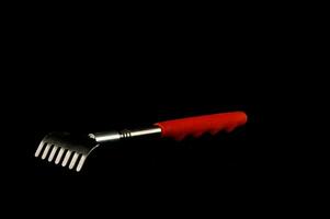 a red and silver fork with a handle photo