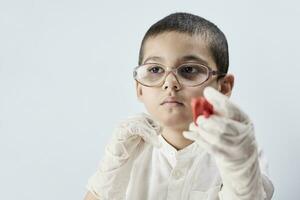 A boy in glasses plays with slime photo