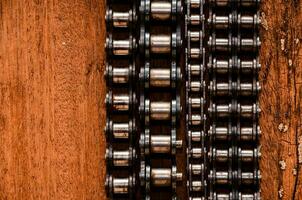 a close up of a chain on a wooden surface photo