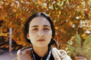 Autumn woman. Fall season concept. A portrait of pretty female with a branch of autumn tree photo