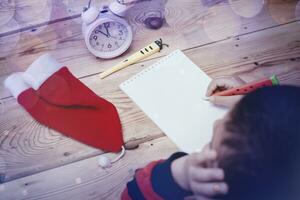 Little boy writing to Santa Claus. A kid writes a letter to Santa Claus. Child thinking, dreaming about Christmas wish photo