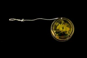 a yellow toy with a string on a black background photo