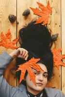 otoño mujer. otoño temporada concepto. un retrato de acostado en de madera piso mujer foto