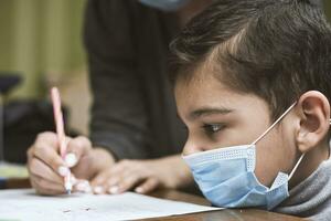 Distance education. Mother helps a pre-school kid to do lessons photo