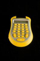 un amarillo calculadora en un negro antecedentes foto