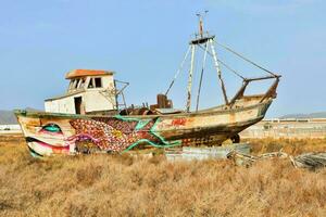 an old boat is covered in graffiti photo