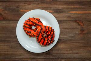 Donuts in black and orange glaze, a dish for Halloween photo