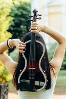un fragmento de un eléctrico violín, un violín en el manos de un del músico muchacha. foto
