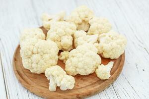 Cauliflower vegetables standing on a white wooden table photo