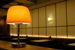 Modern Desk Lamp with Blurred Restaurant Background. photo