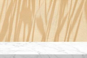 White Marble Table with Grass Leaves Shadow on Beige Stucco Wall Texture Background, Suitable for Product Presentation Backdrop, Display, and Mock up. photo