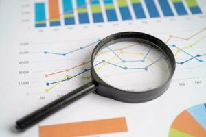 Magnifying glass on charts graphs paper. Financial development, Banking Account, Statistics, Investment Analytic research data economy. photo