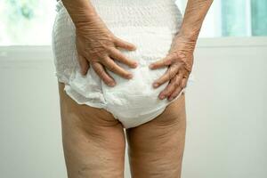Asian senior woman patient wearing incontinence diaper in hospital, healthy strong medical concept. photo