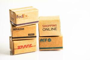 Bangkok, Thailand September 26, 2022 Shopping cart with DHL Amazon and FedEx express packing box, import export online exchange investment business. photo