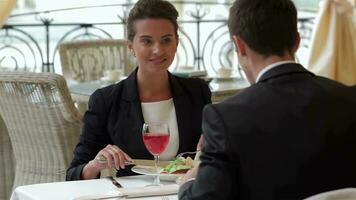 Businesswoman eating with a businessman video