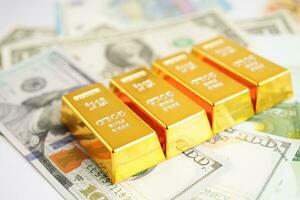 Gold bars with US dollar and Euro banknote money, finance trading investment business currency concept. photo