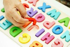 Asian elderly woman playing puzzles game for treatment dementia prevention and Alzheimer disease. photo