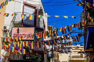 small rainbow flag against the sky in a Spanish city photo