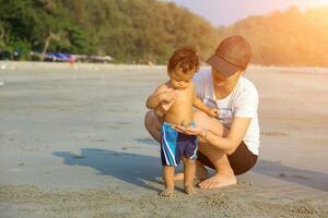 Mother and son playing on the beach photo