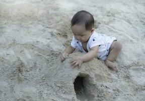 Asian toddler baby thai girl playing with sand photo