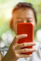 Focus hand of Young asian woman touching red smartphone photo