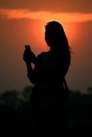 silhouette asian woman touching smartphone at Sunset time photo