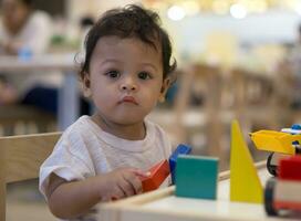 Asian toddler Playing with colorful wooden toy. photo