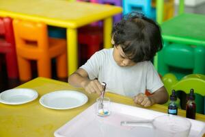 3 year old children in Asia are conducting scientific experiments. photo