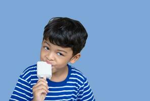 Little Thai boy eating white chocolate Ice cream photo