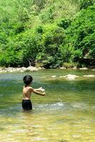 Asian boys playing water in theriver photo