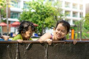 Asian child boy learn swimming in a swimming pool with mom. - Sunset filter effect photo