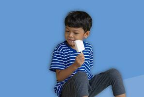 Little Thai boy eating white chocolate Ice cream photo