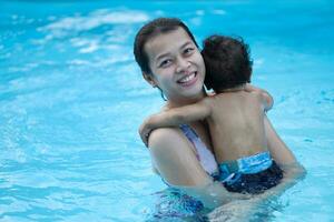 Mother and asian baby first time in a swimming pool photo